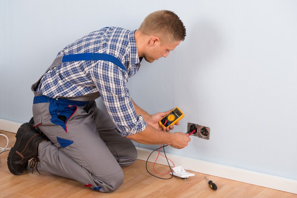 Electrician Checking Voltage Of Socket With Multimeter In House — Level 2 Electrician Near Me in Lake Macquarie NSW