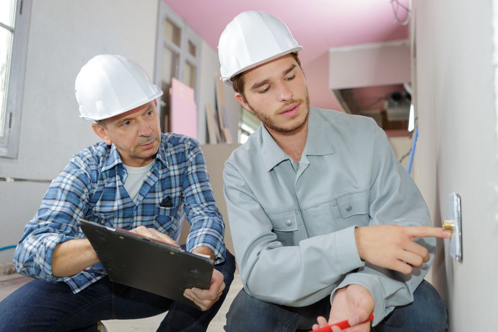 Electricians installing socket in new house — Level 2 Electrician Near Me in Newcastle NSW