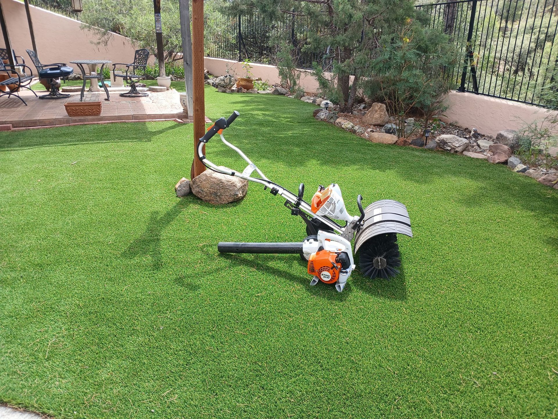A lawn mower is sitting on top of a lush green lawn.