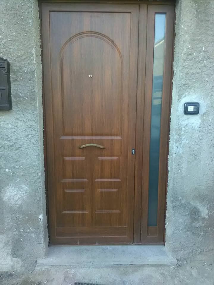 Primo piano di una porta bianca con maniglia e serratura argentate.