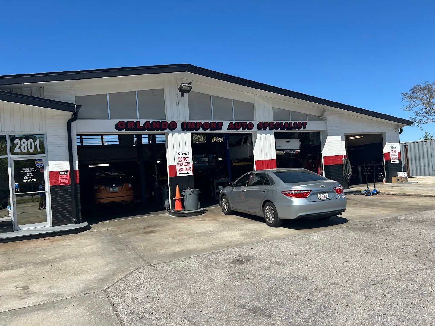 Orlando House Auto Service shop with a silver car parked outside.