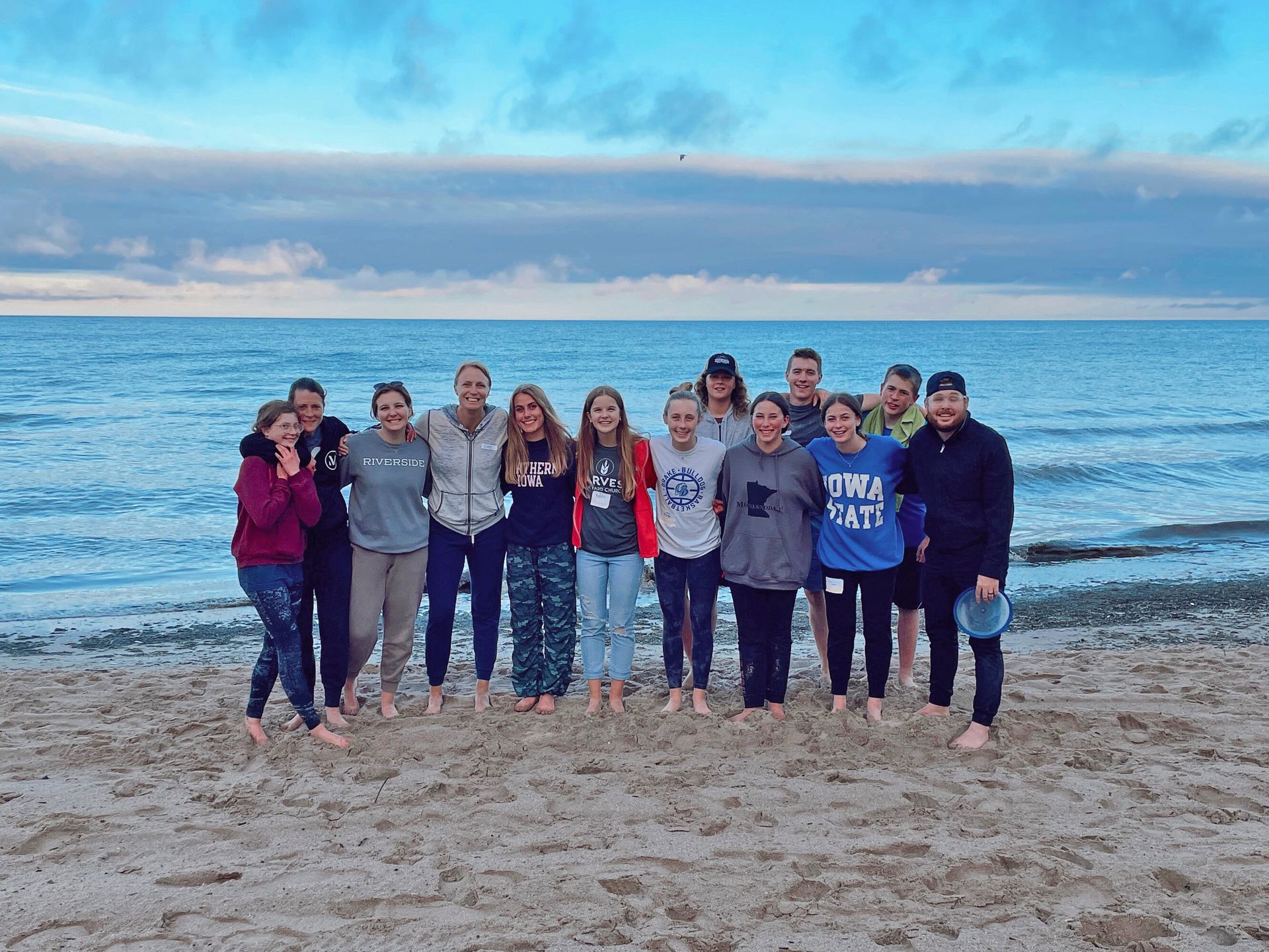 A group of people are posing for a picture on the beach.