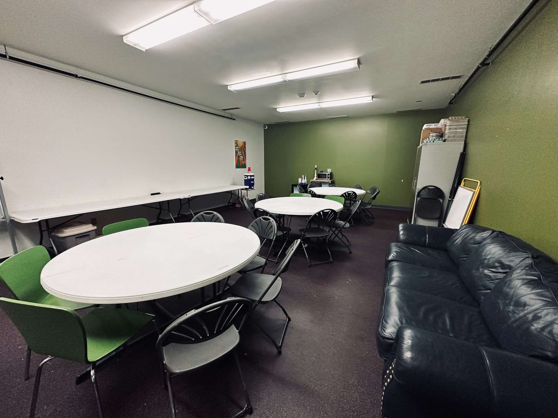 A room with tables and chairs and a couch.