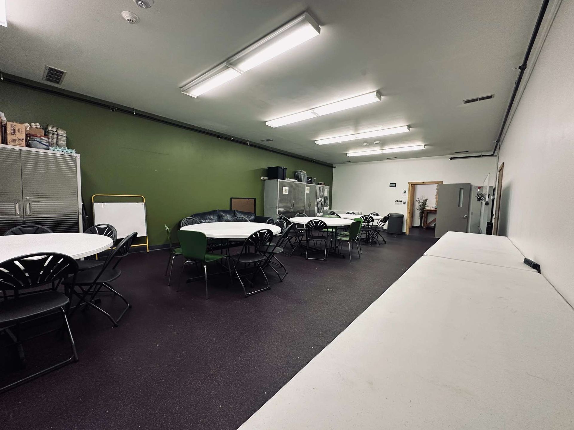 A large room with tables and chairs in it.