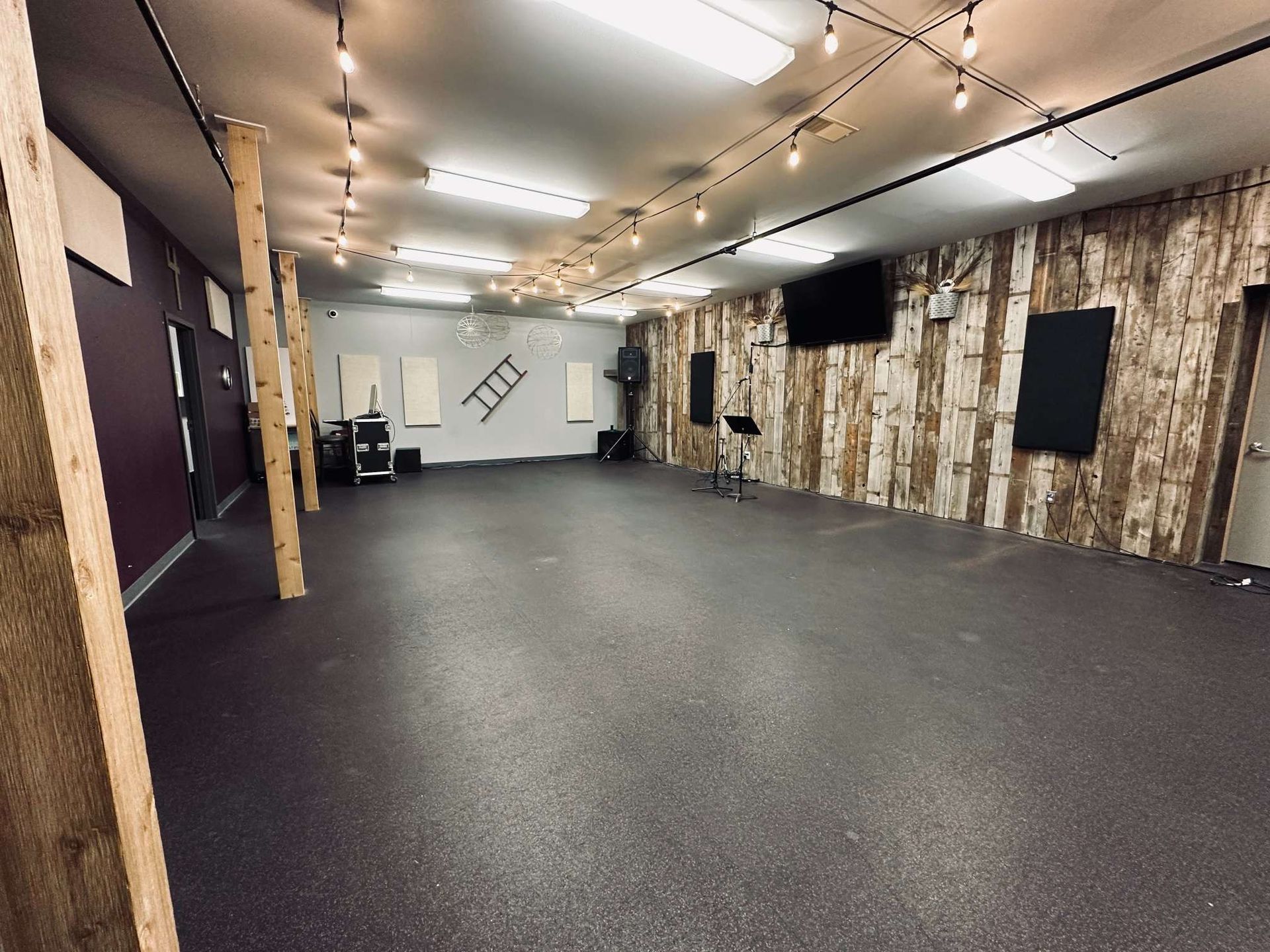 A large empty room with a ladder on the wall