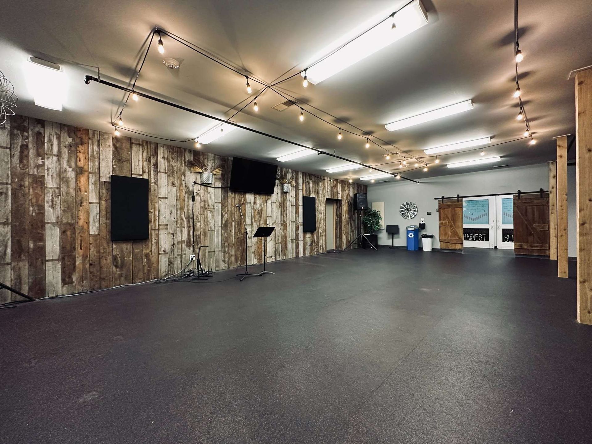 An empty room with a wooden wall and a black floor