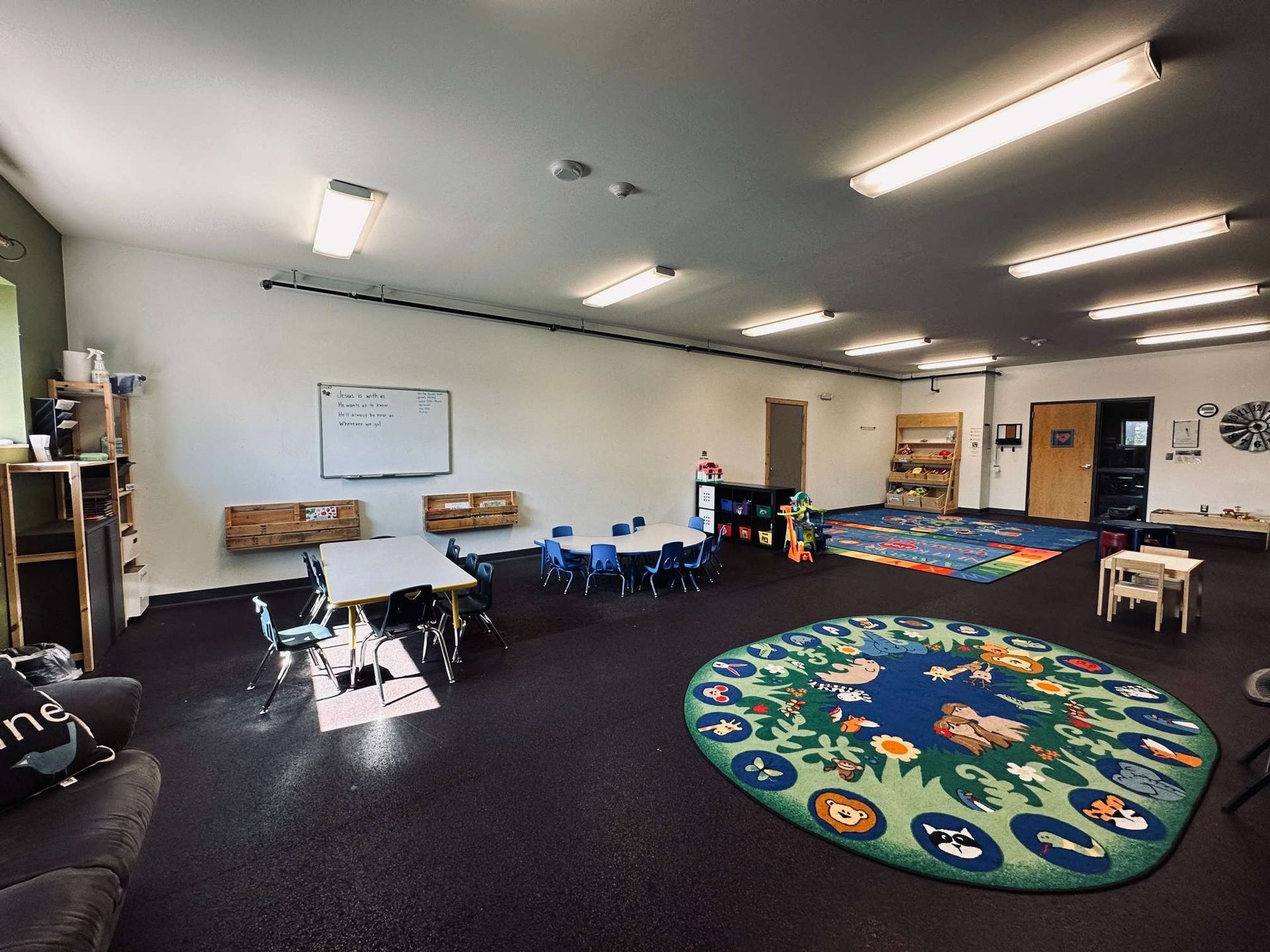 A large room with tables and chairs and a rug