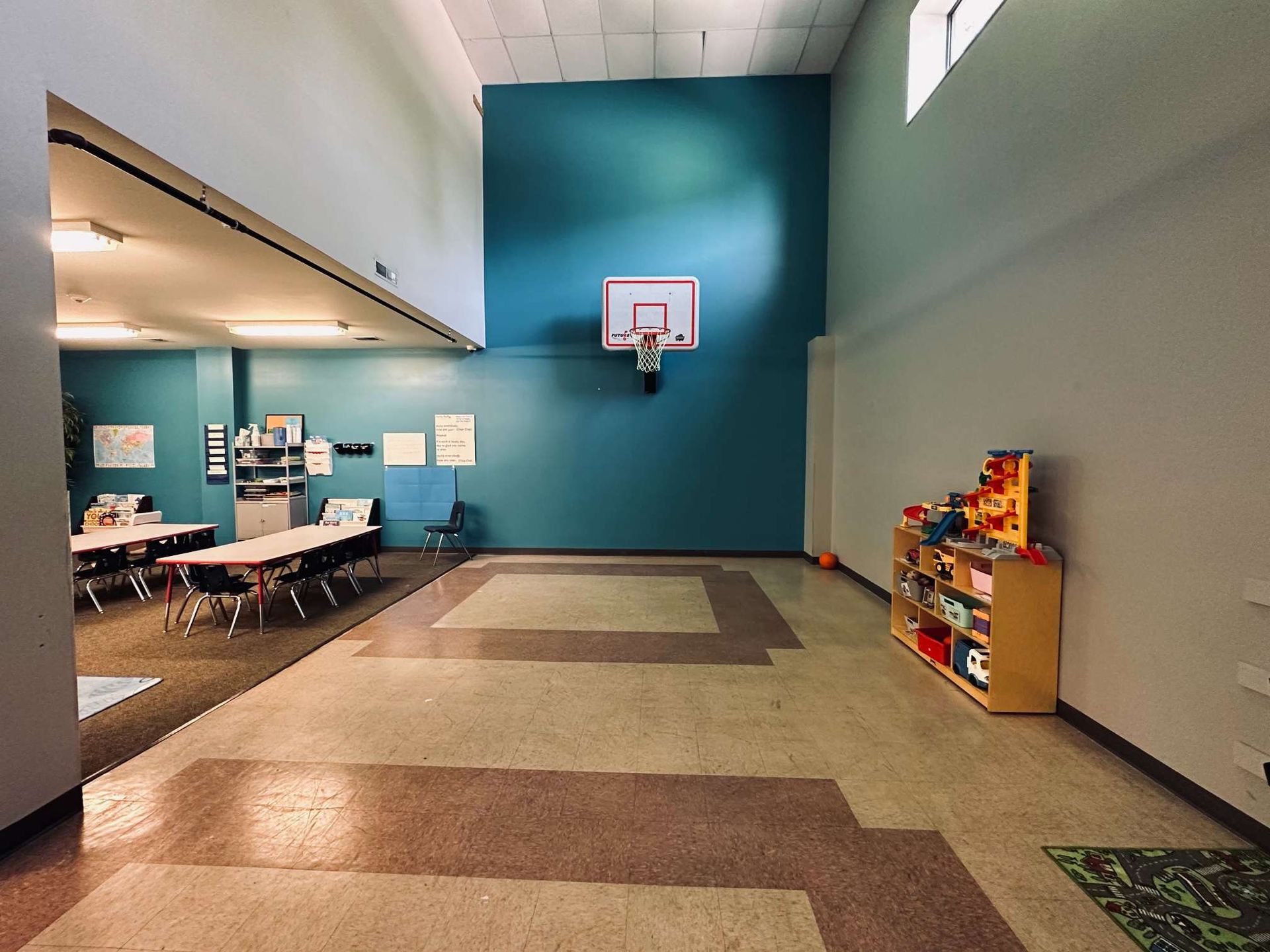 A large room with a basketball hoop on the wall.