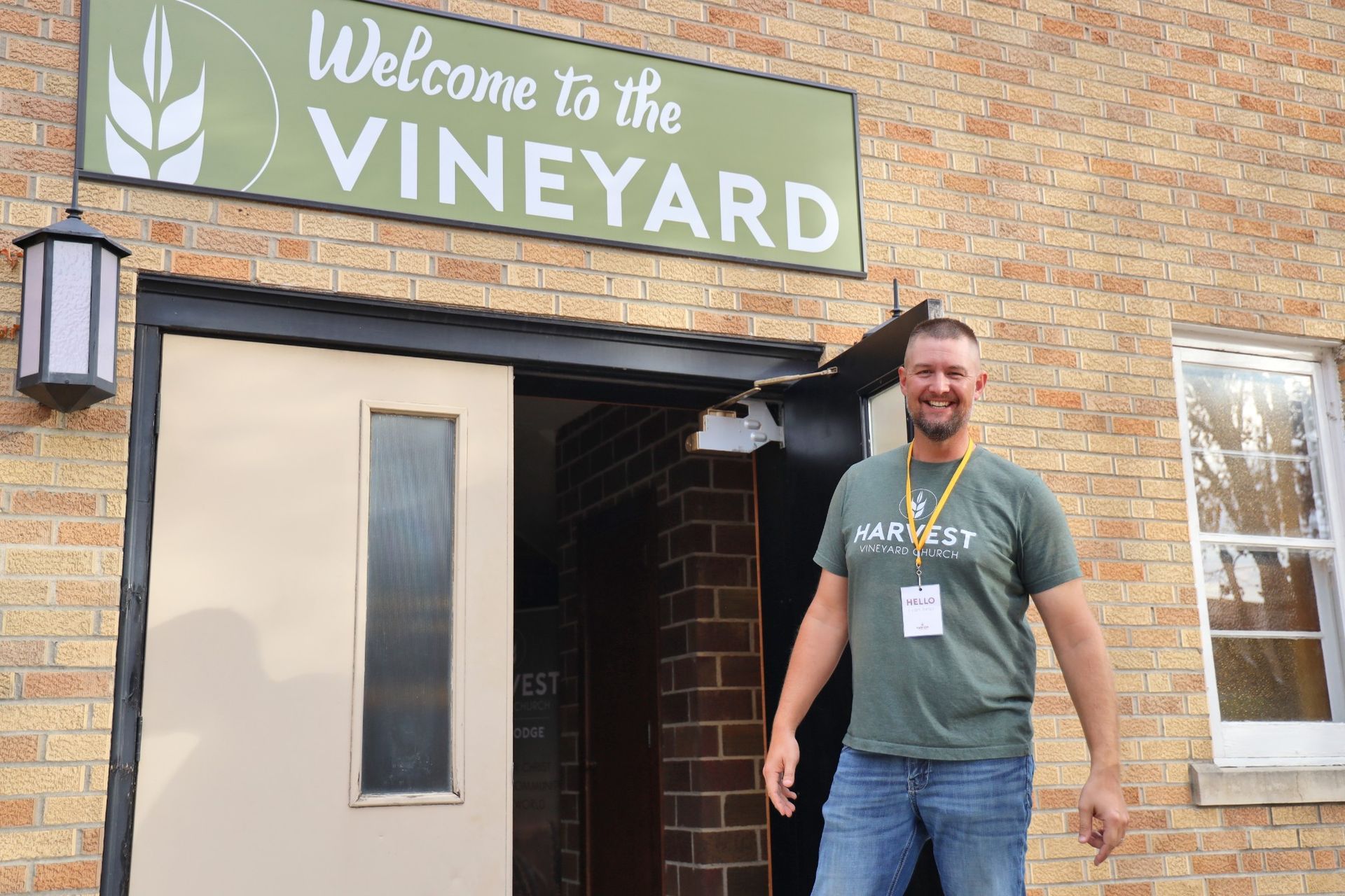 Man standing in front of a church sign that reads 