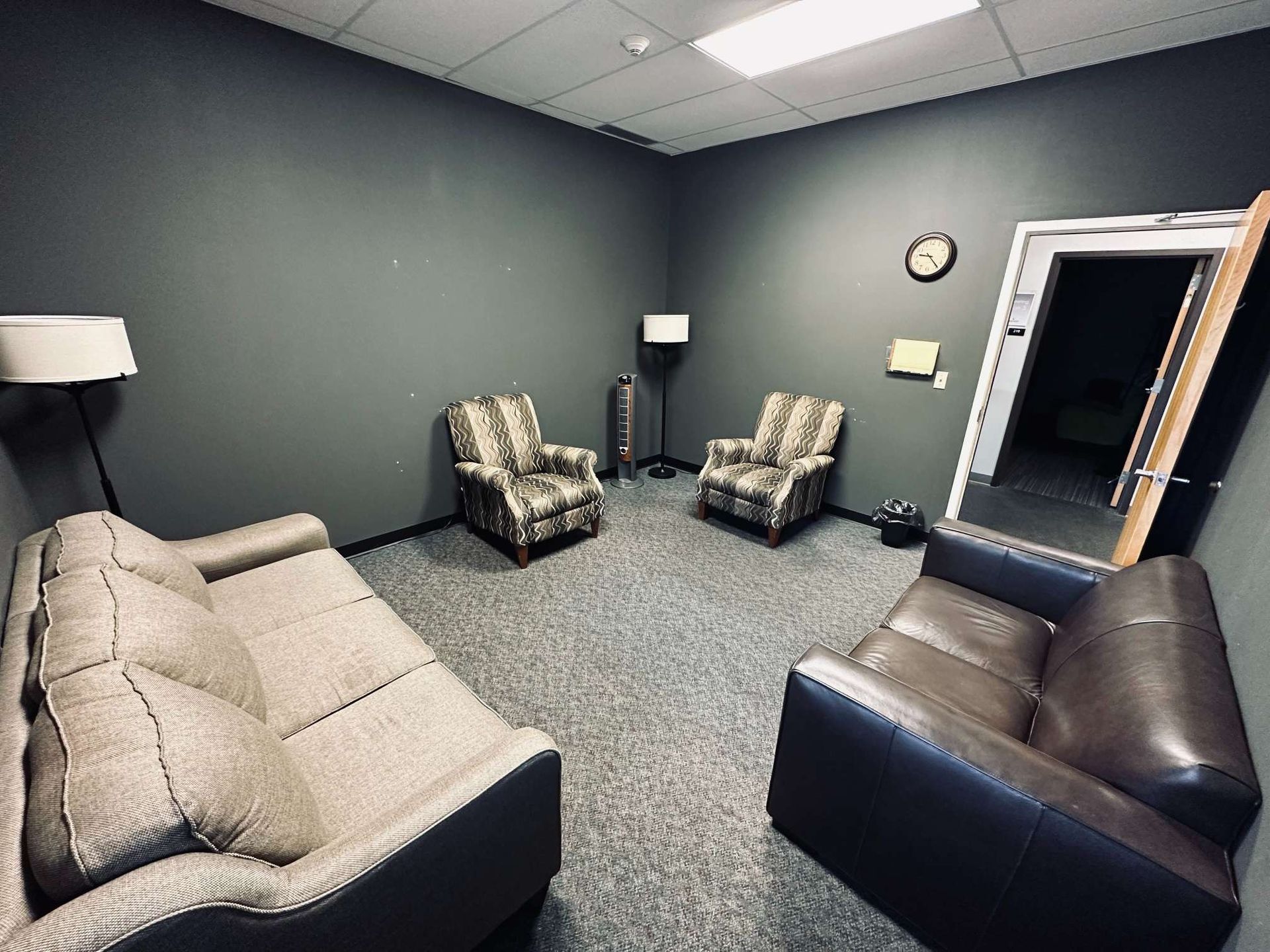 A living room with a couch , chairs and a mirror.
