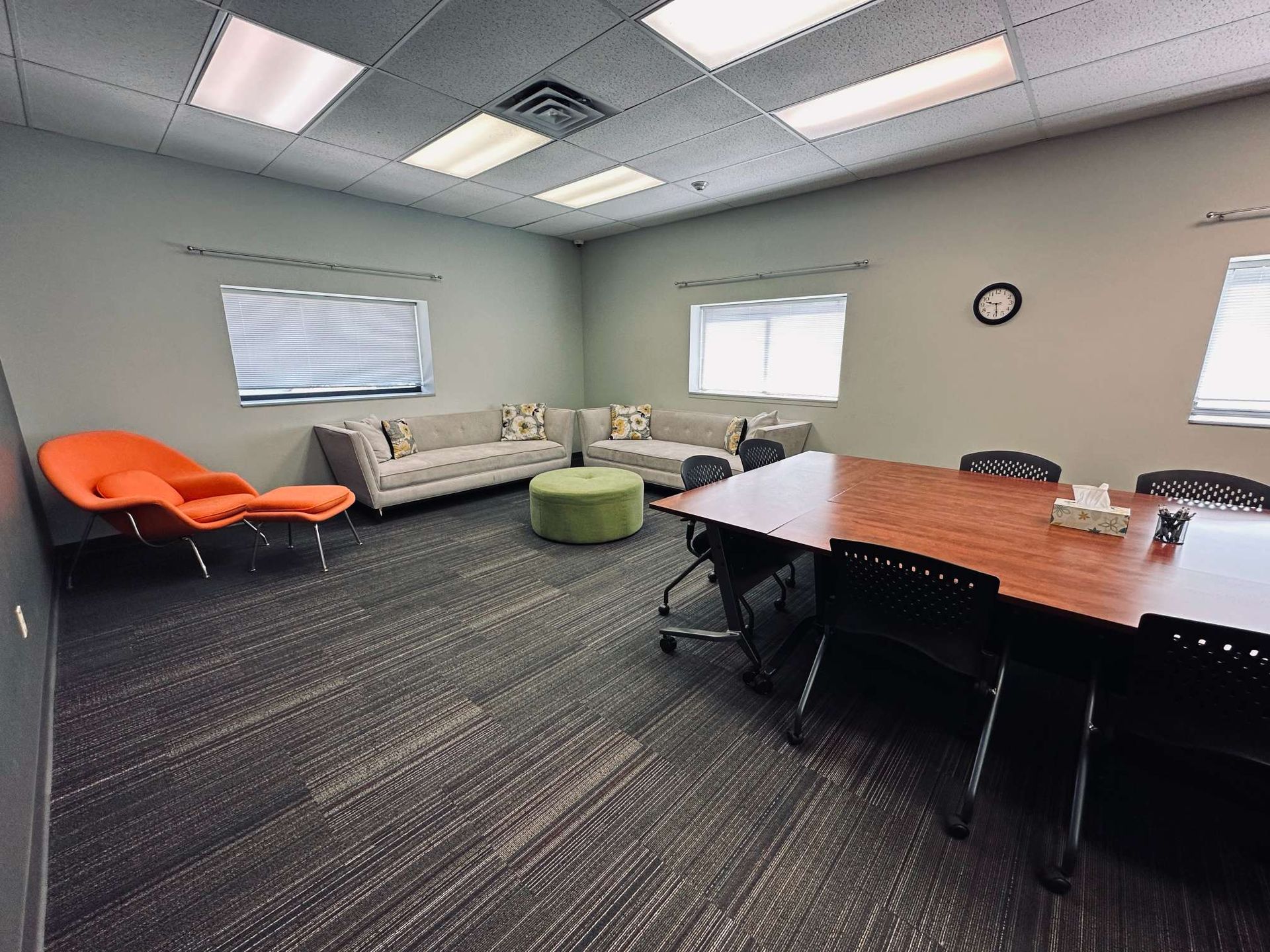 A conference room with a table , chairs , and a couch.