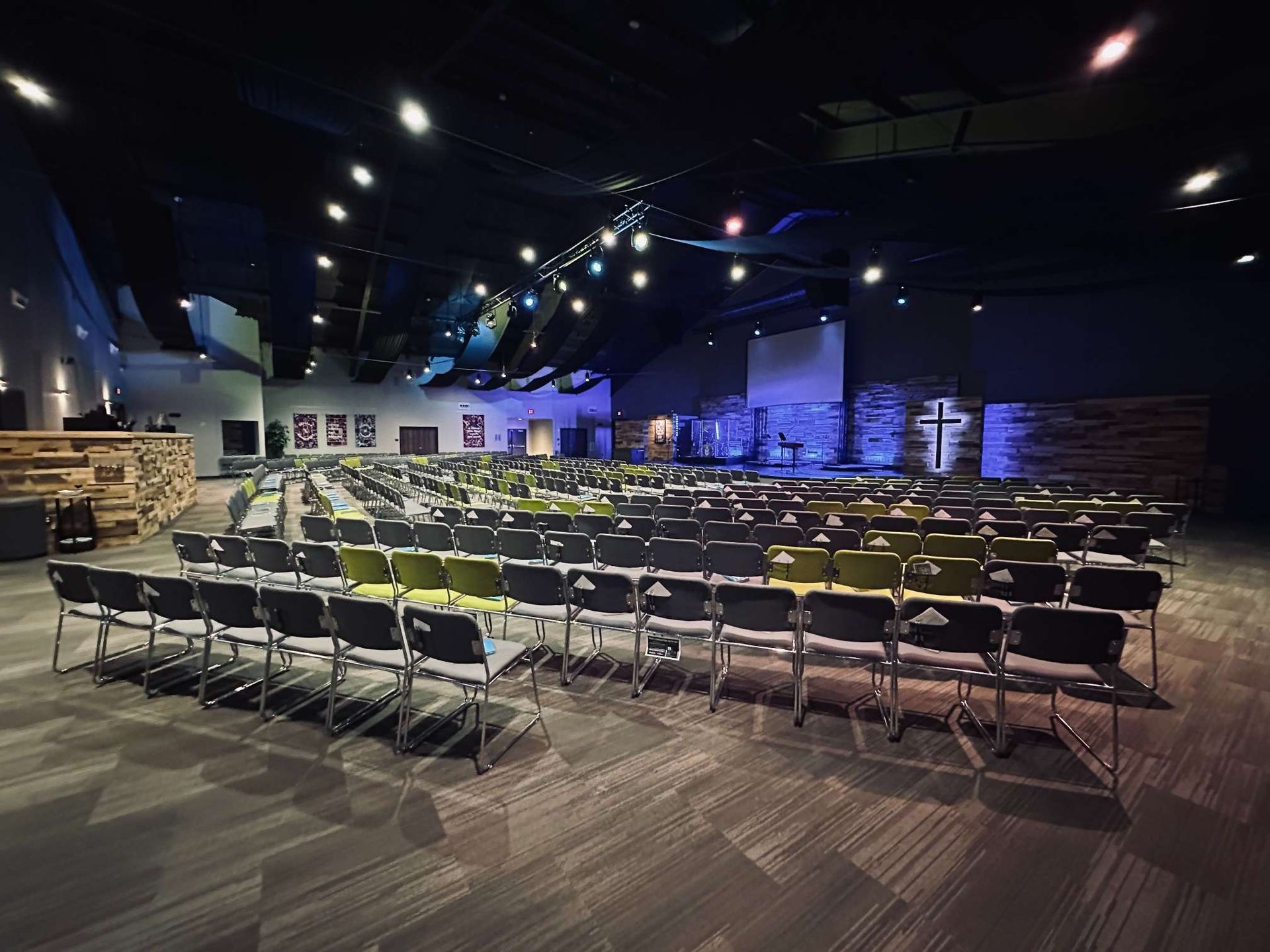 A large auditorium filled with rows of chairs and tables.