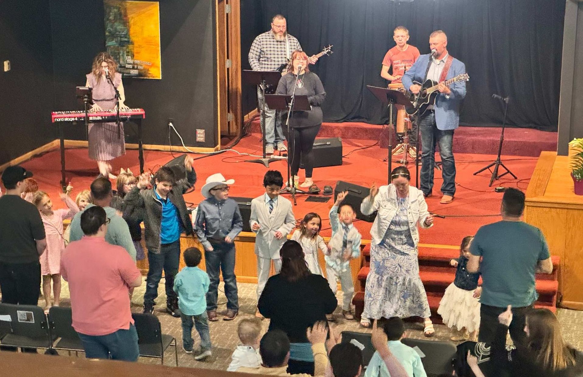 Band performing on stage with people dancing in front.