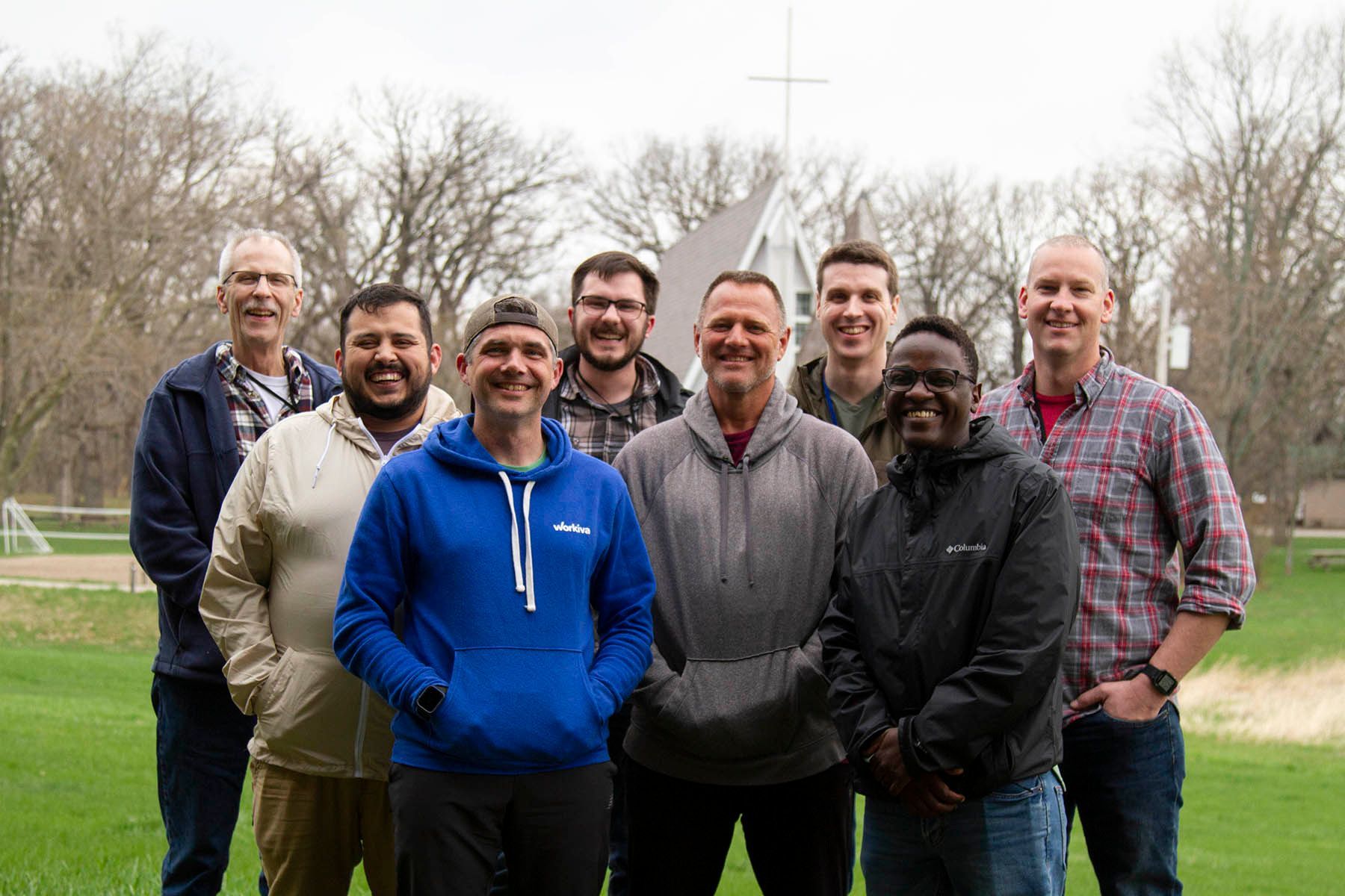 A group of men are posing for a picture in a field.