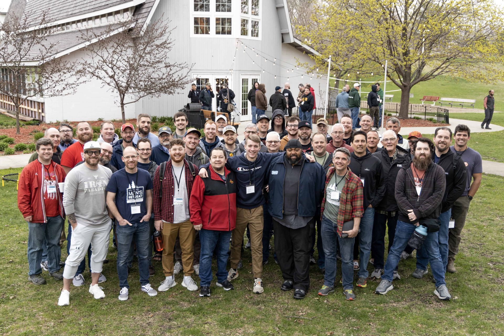 A large group of people are posing for a picture in front of a white building.