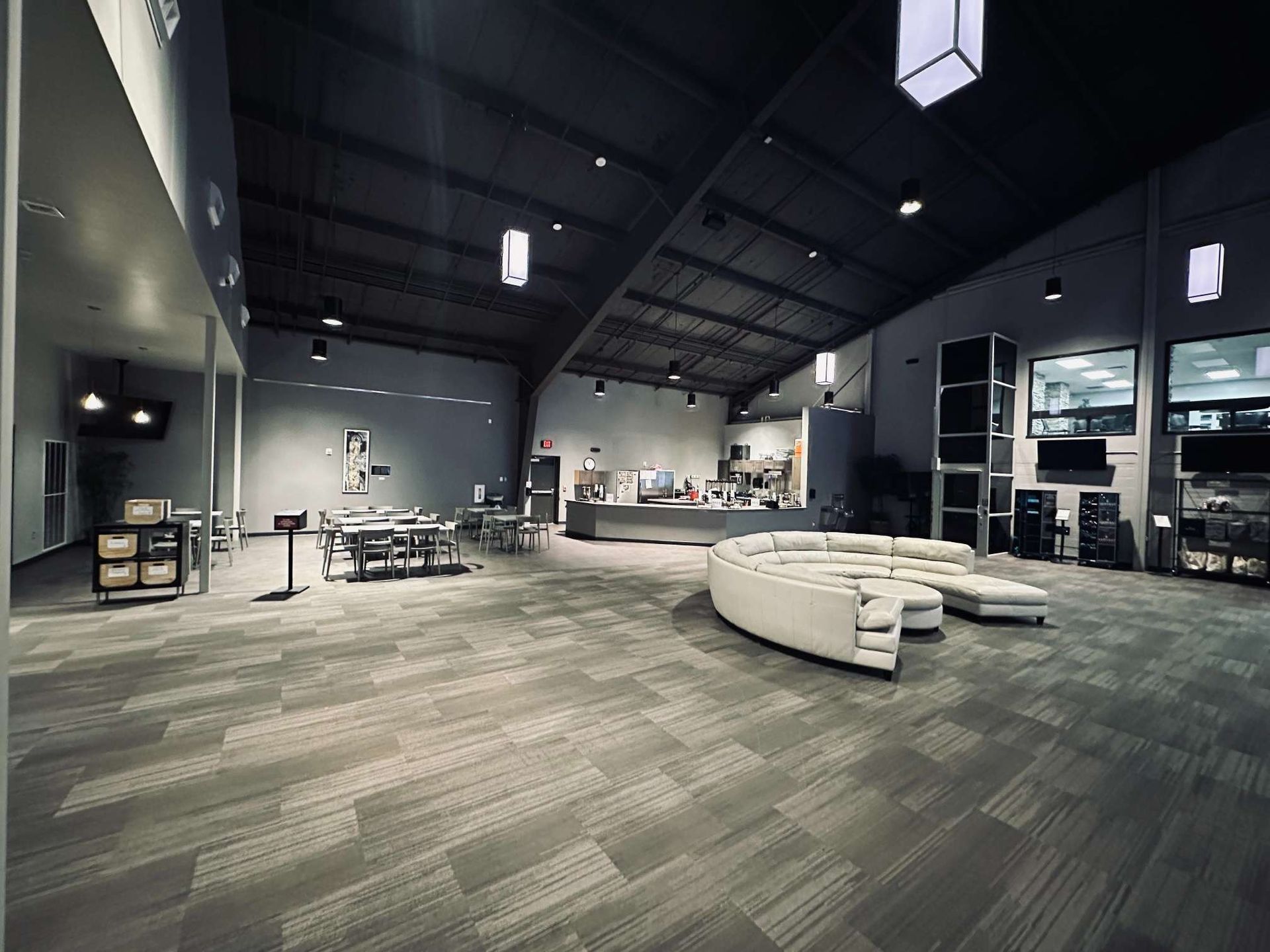 A large room with a couch and tables in it.