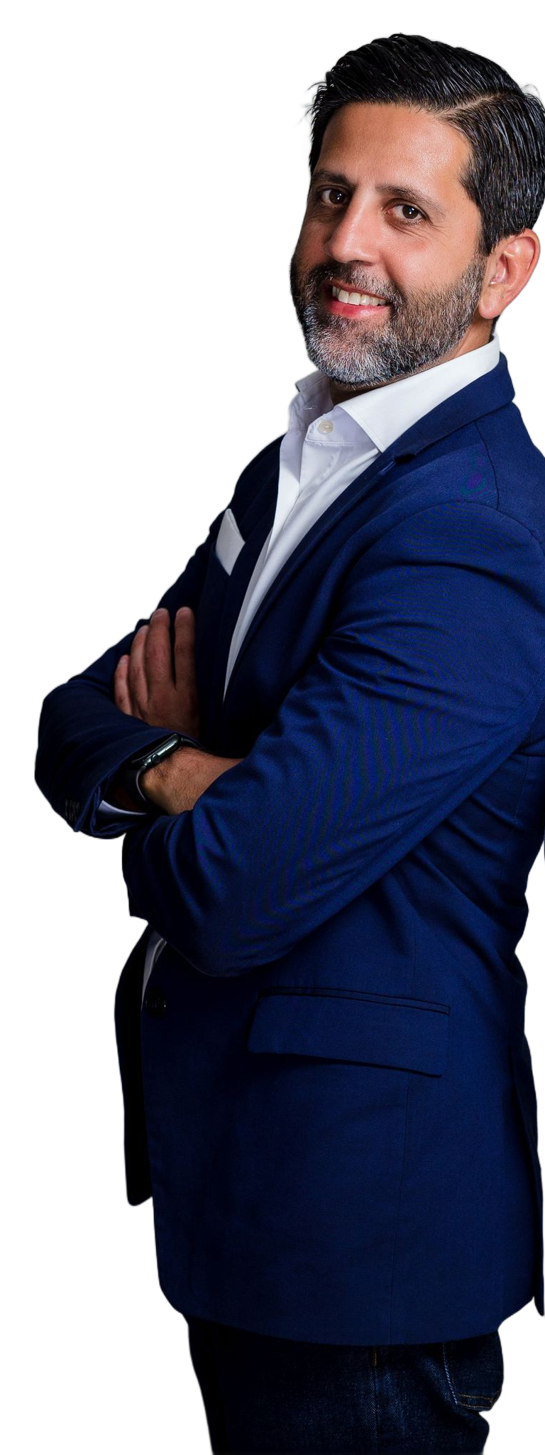 A man with a beard, wearing a blue blazer and white dress shirt, stands with his arms crossed against a white background.
