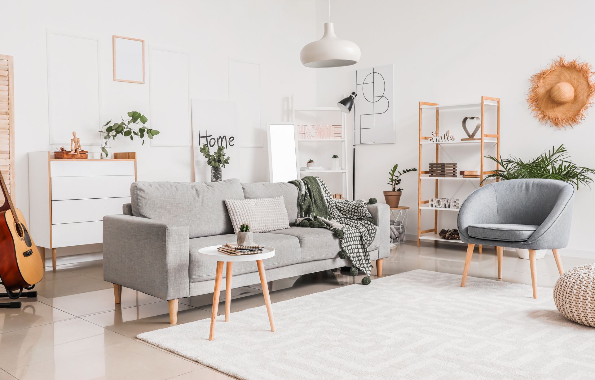 Cozy living room with grey sofa, white walls, wooden accents, and a neutral rug.