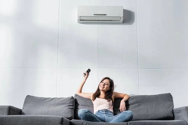 Woman adjusting AC during summer heat