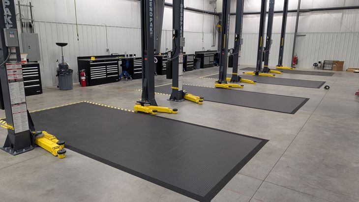Interior of an industrial warehouse with workbenches, tools, and equipment on a concrete floor