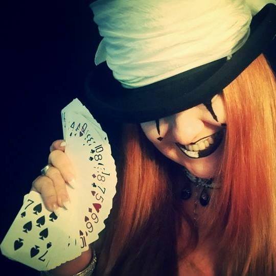 A woman in a top hat is holding a fan of playing cards, representing Fortuna.