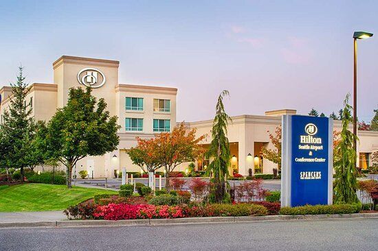 A large hotel with a blue sign in front of it.