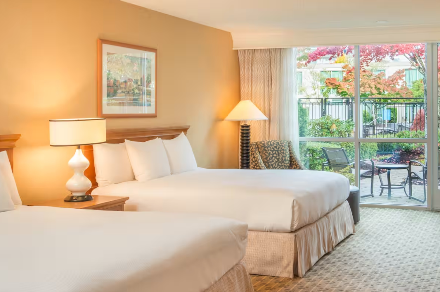 A hotel room with two beds and a large window