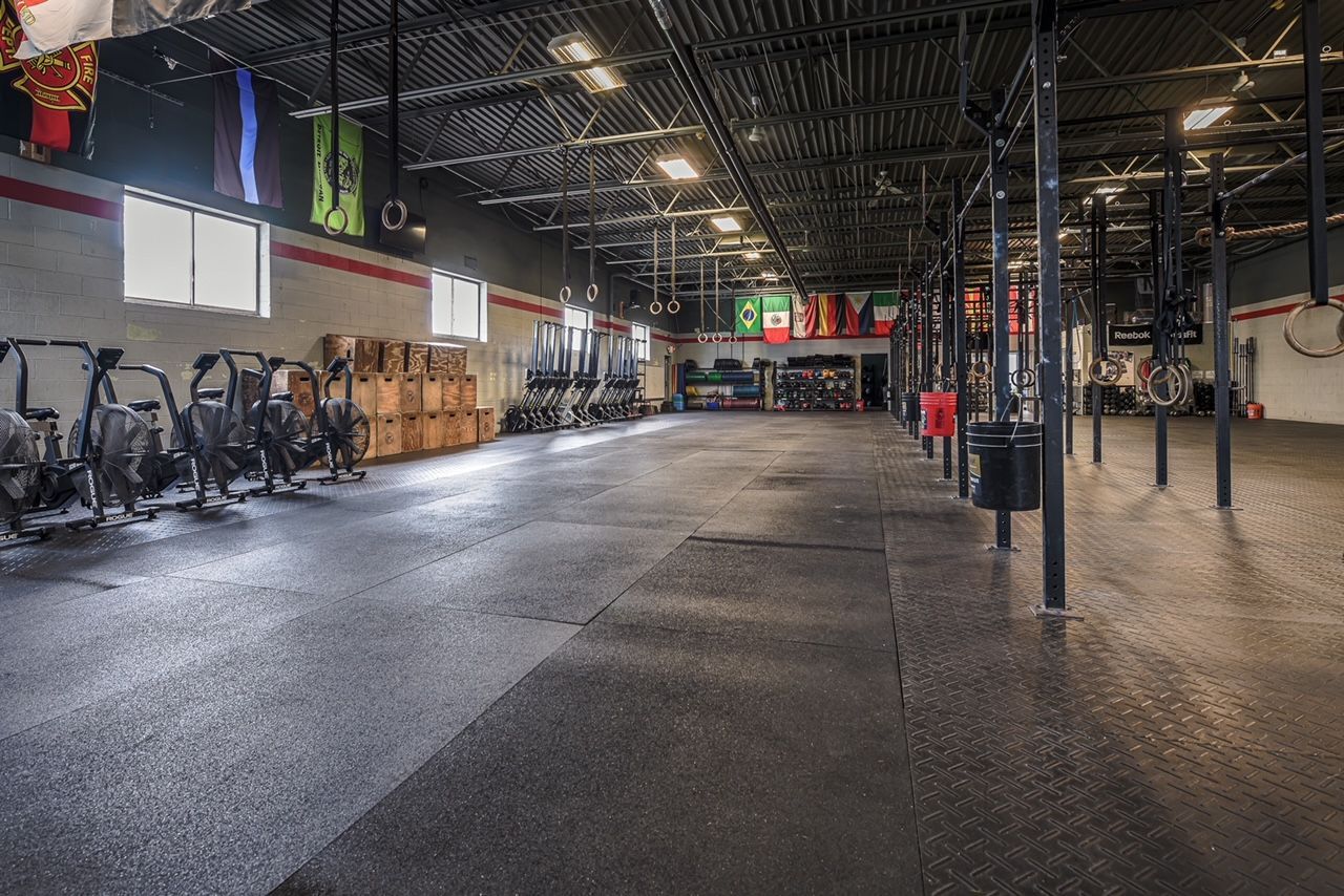 A large empty gym with a lot of exercise equipment.