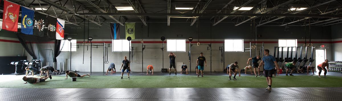 A group of people are doing exercises in a gym.