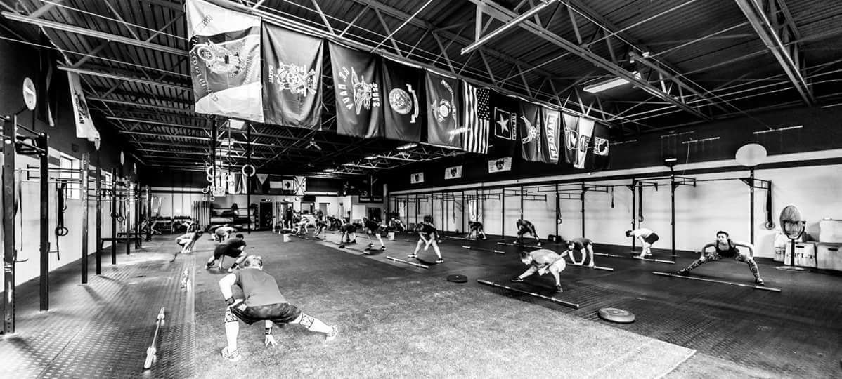 A black and white photo of a gym with flags hanging from the ceiling.