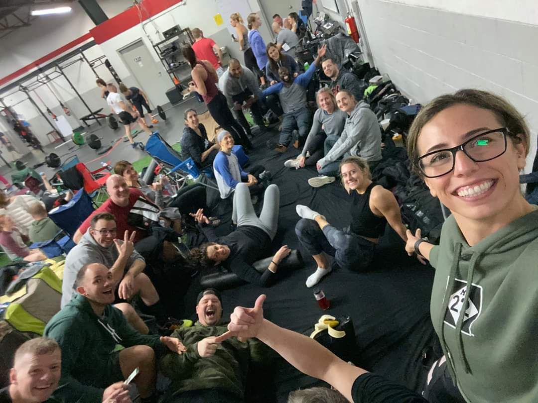 A group of people are sitting on the floor in a gym.