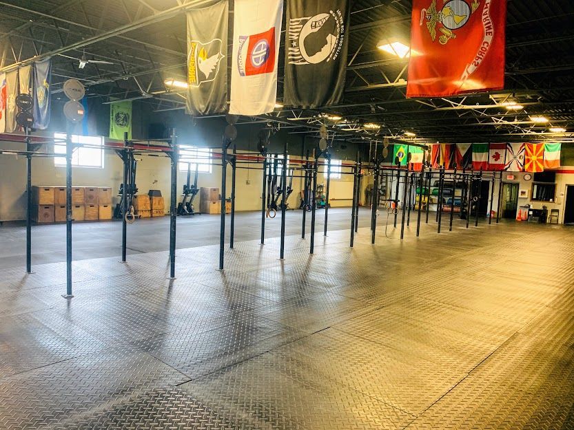 A large empty gym with flags hanging from the ceiling.
