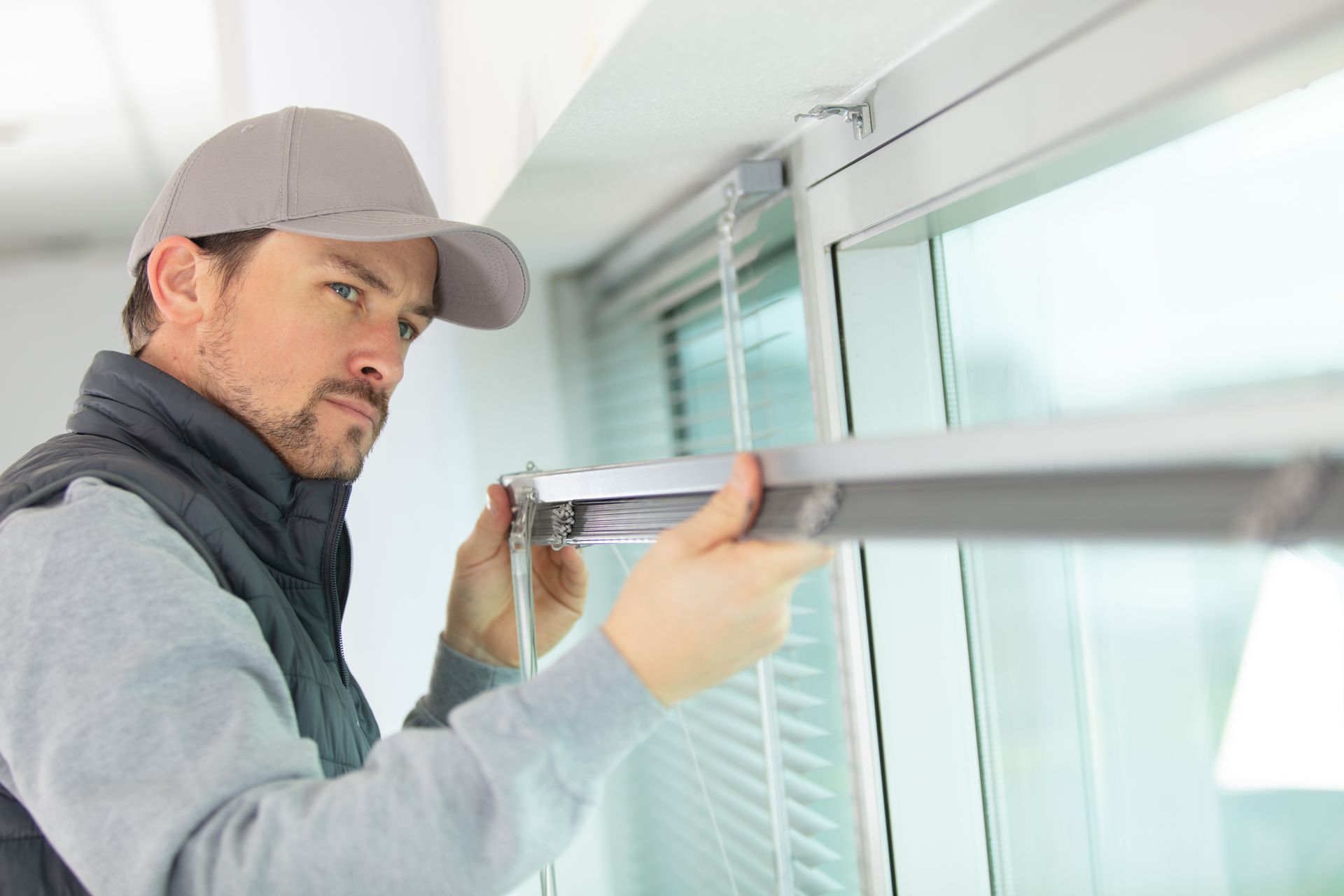 Window installer fitting residential window frame during home improvement service. Window installer fitting residential window frame during home improvement service.