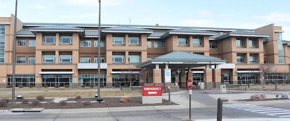A large brick building with a lot of windows and a red box in front of it.