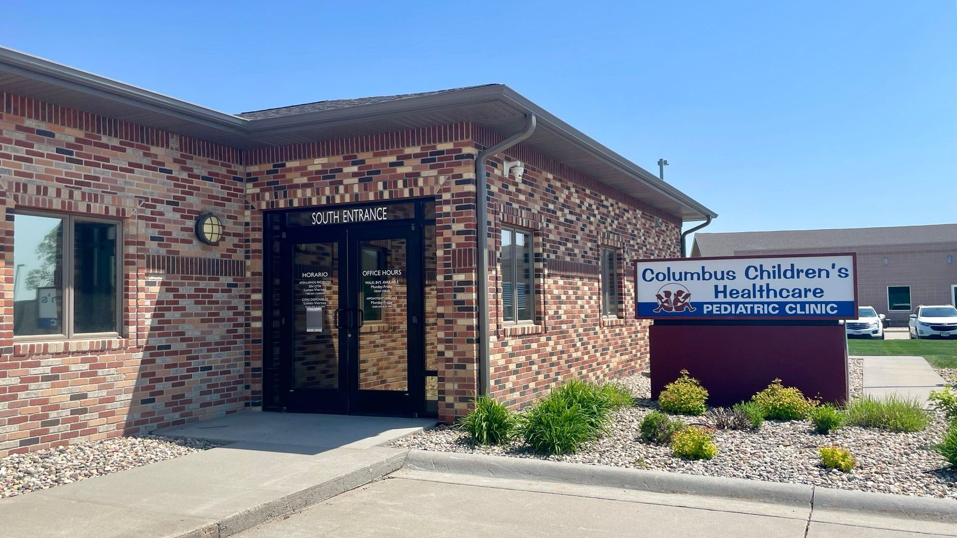 A brick building with a sign in front of it that says `` dr. lewis children 's healthcare ''.