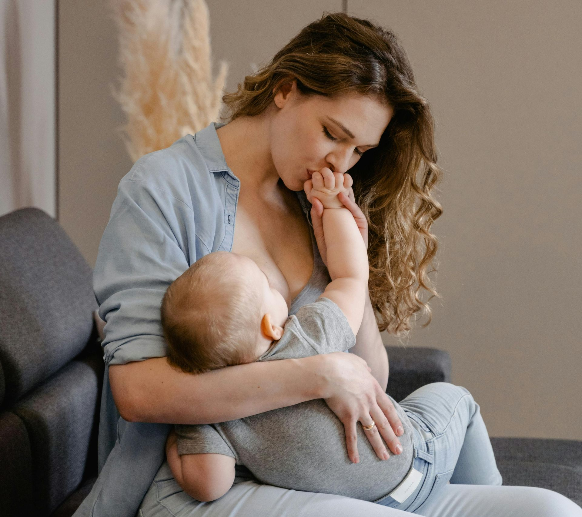 A close-up of a person holding a baby, who is looking directly at the camera with a neutral expression.