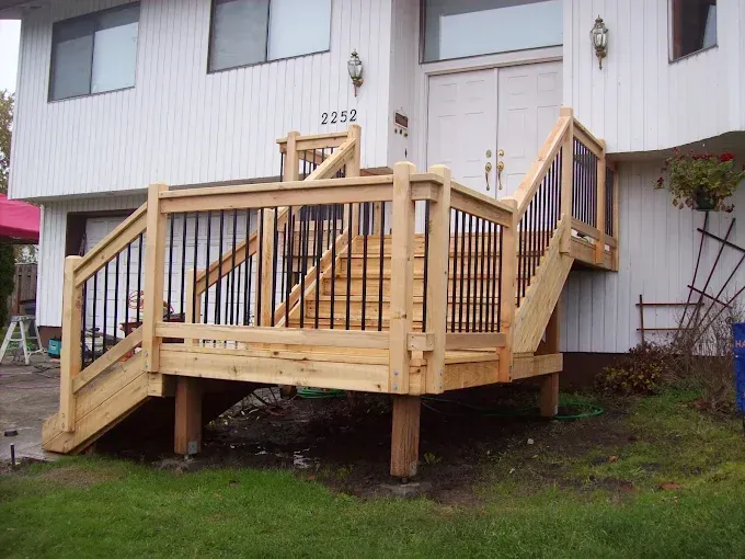 Wooden accessibility ramp with railings leading to apartment doors