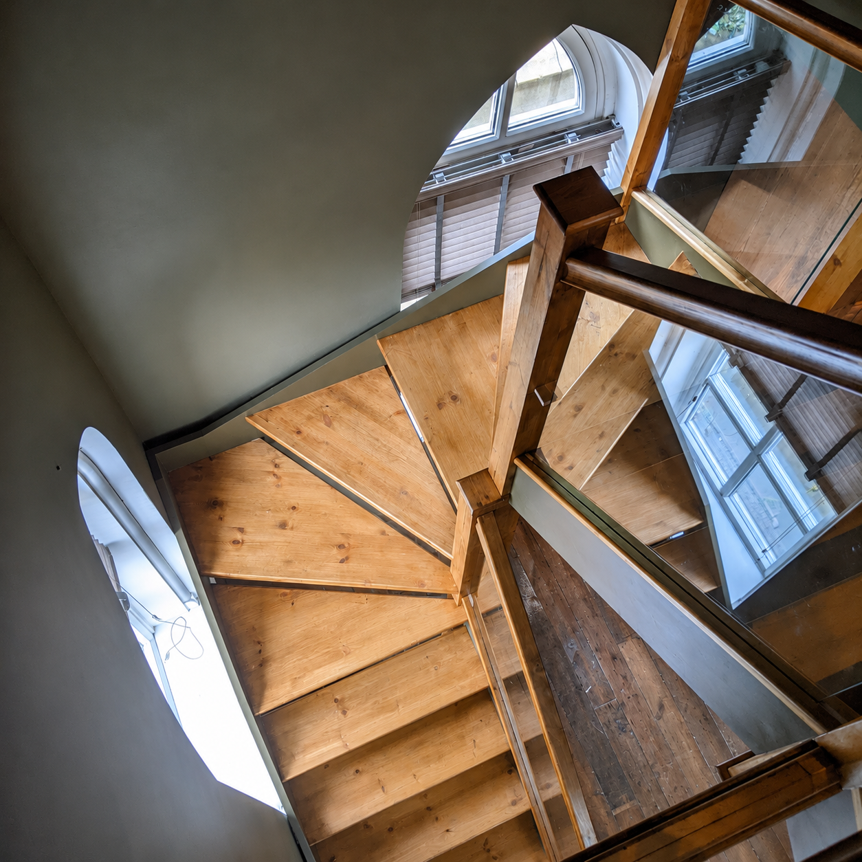 Space-saving wooden staircase with winder steps and glass balustrade