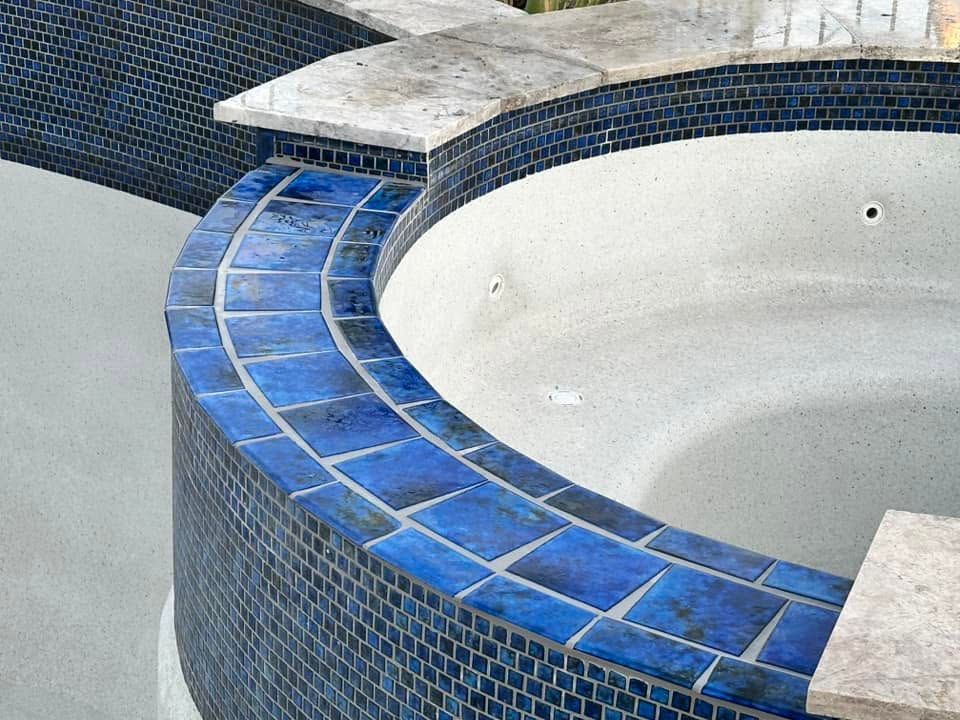 Blue-tiled circular pool or fountain basin with a curved ledge and white interior.
