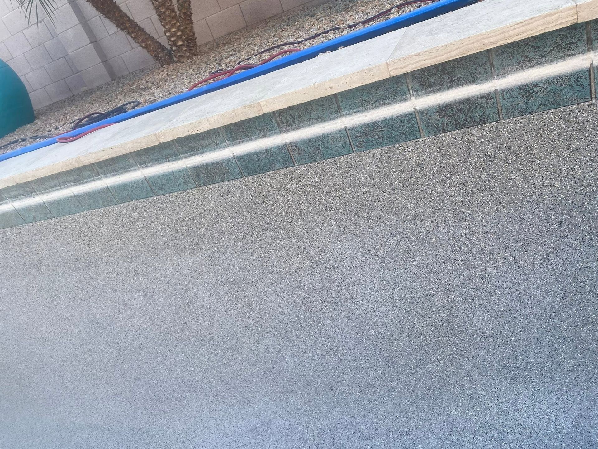 Close-up of a gray speckled surface with a white trim and blue edge along the top