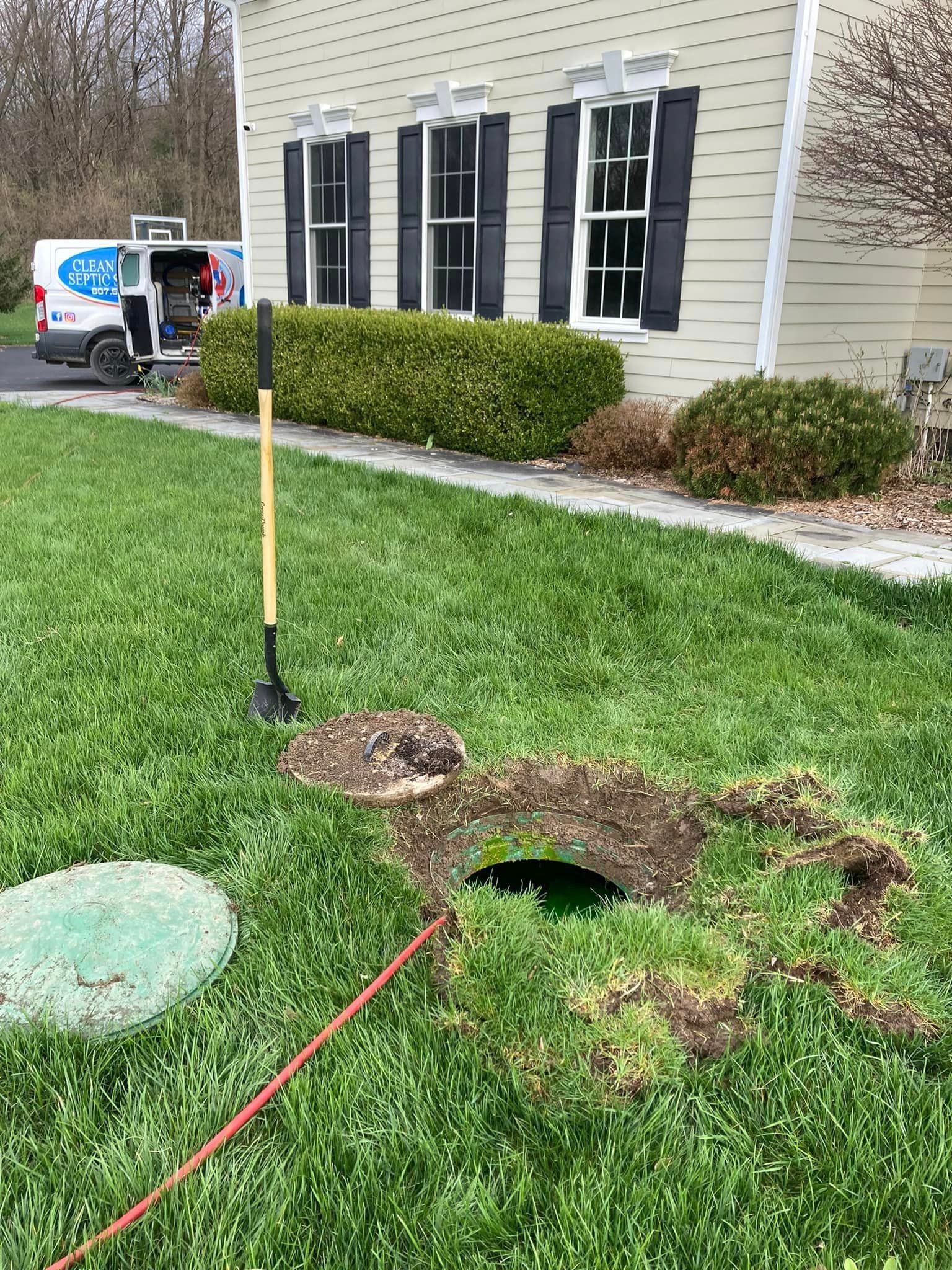 septic system being serviced, open manhole cover in grassy yard in Ithaca, NY | Clean Earth Septic 