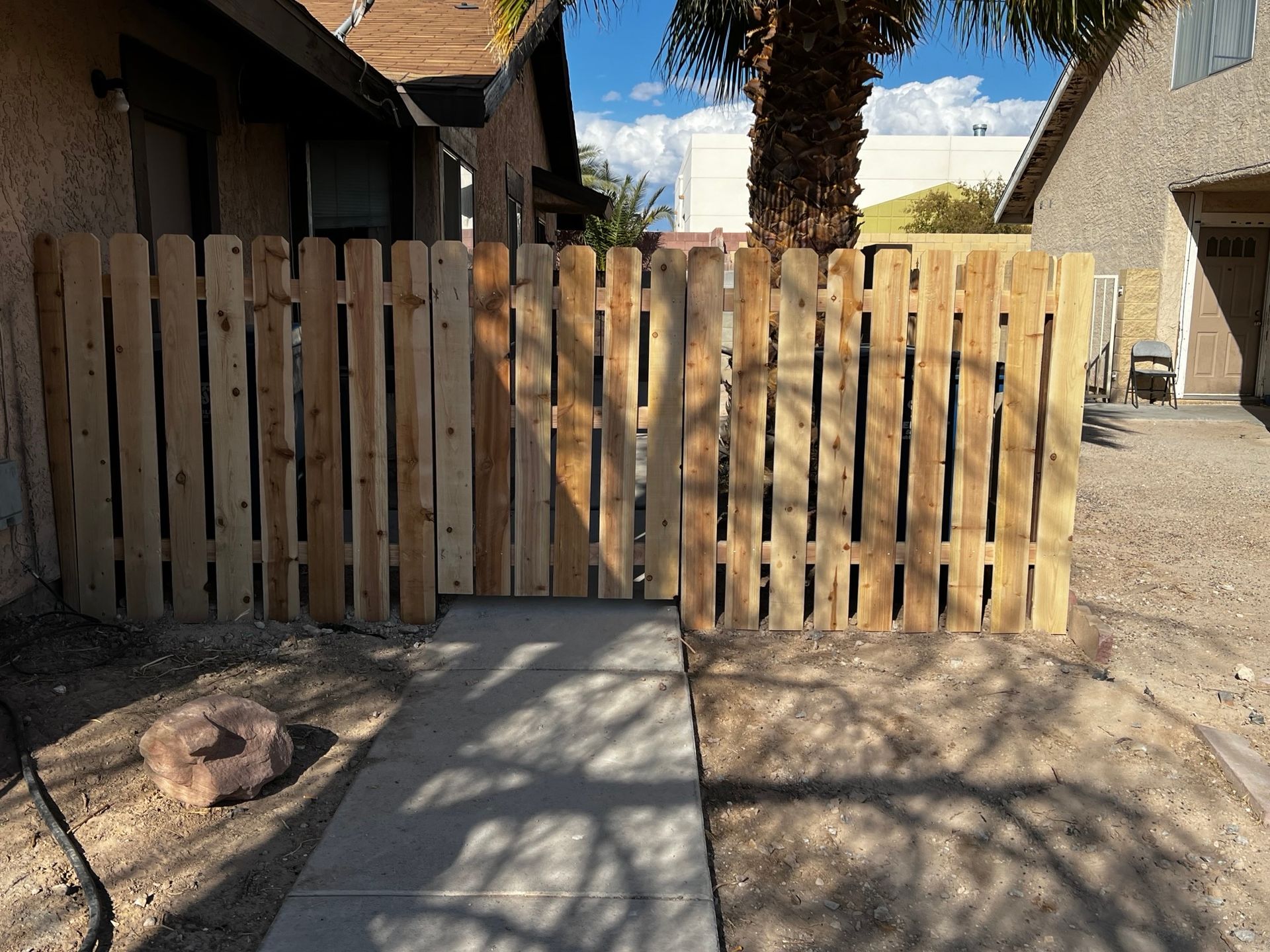 Wooden fence in a sunny outdoor setting with a clear blue sky above.