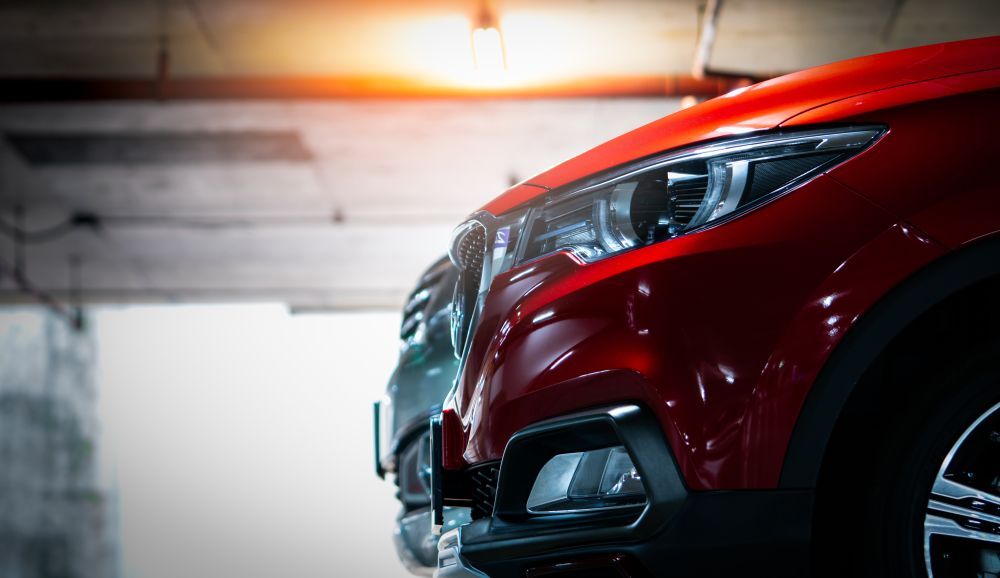 A Red Car is Parked Next to a Black Car in a Garage — AVA Automotive Repairs in Oak Flats, NSW