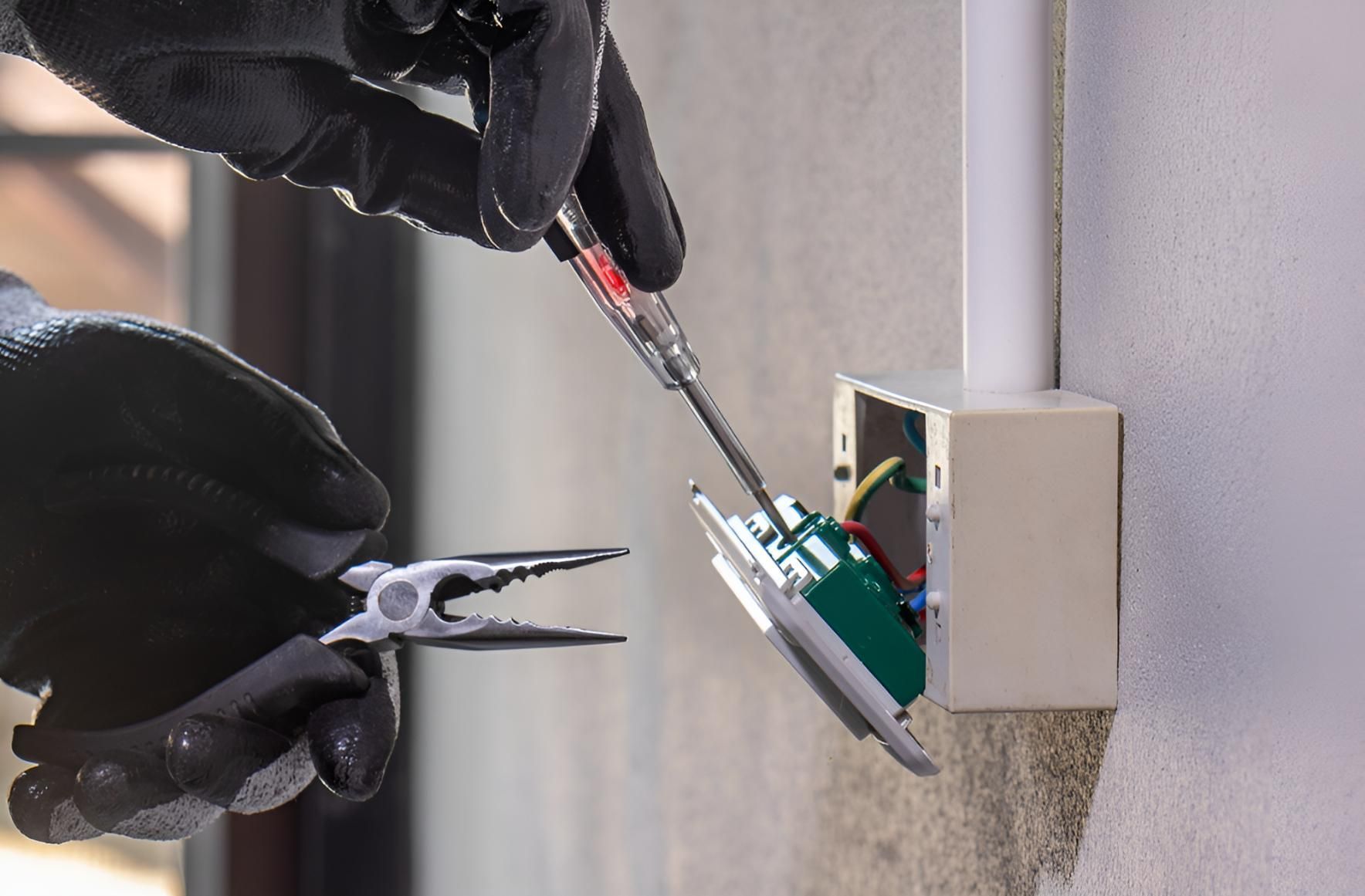 Person is Using a Screwdriver to a Light Switch — Robbie McDonald Electrical in Coolum, QLD