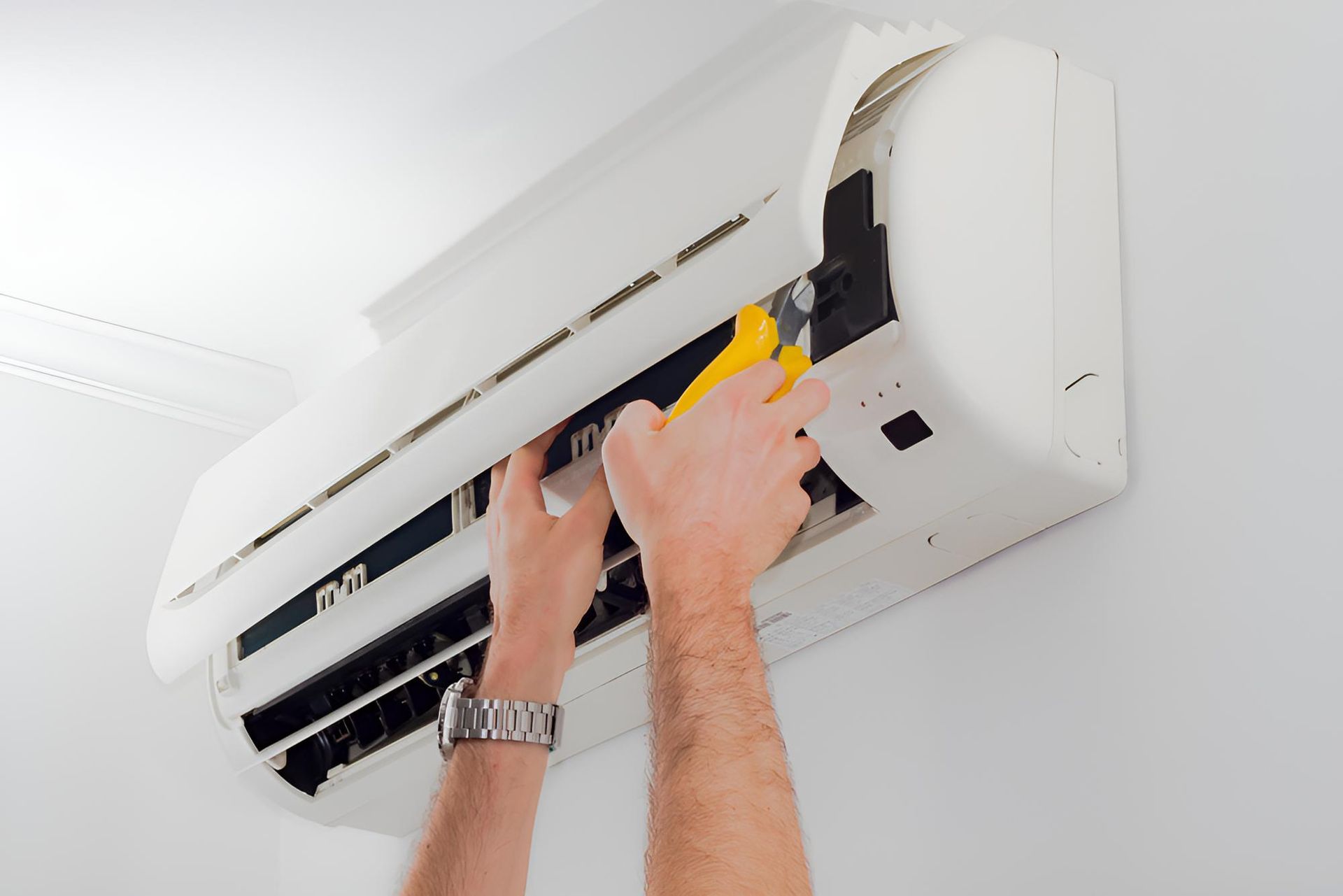 Man is Fixing an Air Conditioner — Robbie McDonald Electrical in Mooloolaba, QLD