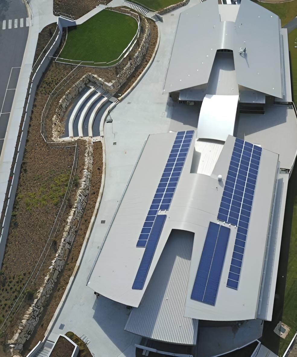 Aerial View of a Building with a Metal Roof and Solar Panels — Robbie McDonald Electrical in Sunshine Coast, QLD