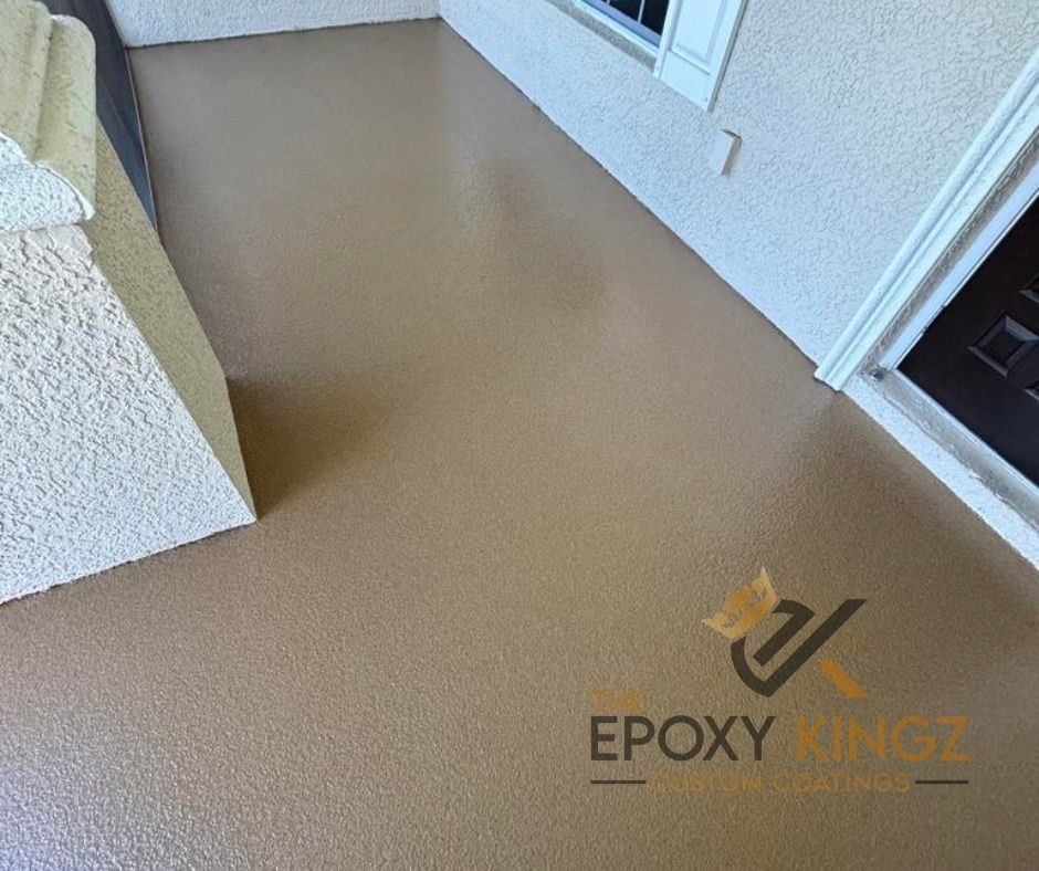 A team of professionals from The Epoxy Kingz applying a resin topcoat to a residential garage floor.