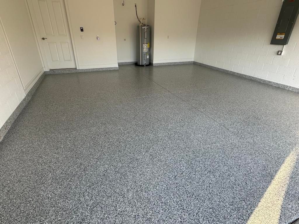 A garage with a gray epoxy floor. Walls are white with a gray border.