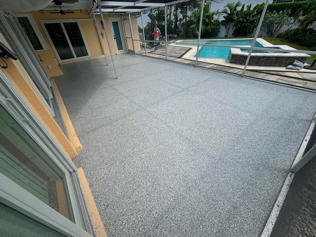 Gray speckled epoxy floor on a patio, overlooking a pool and spa.