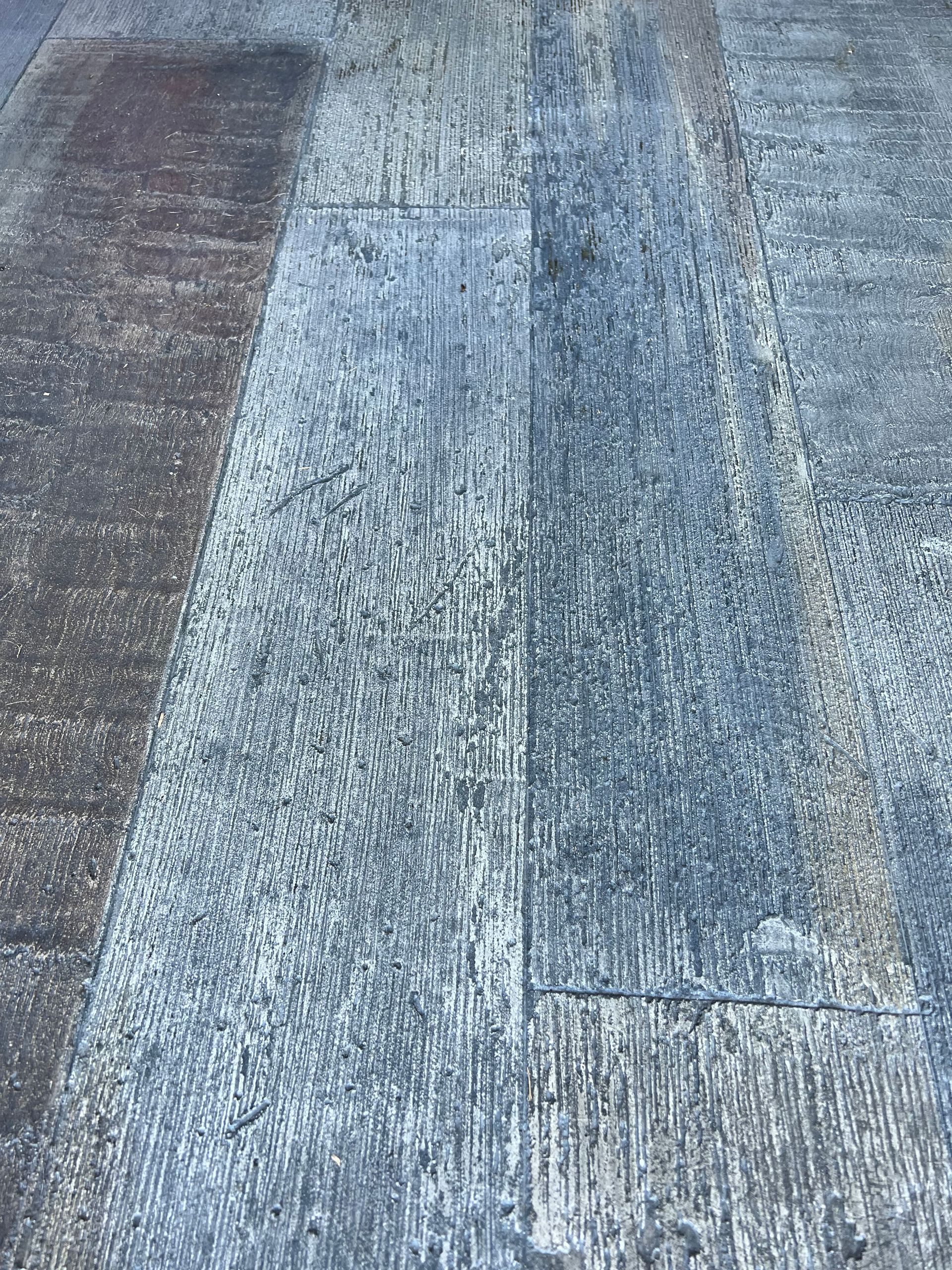 Weathered, gray stone walkway with visible lines and varying textures.